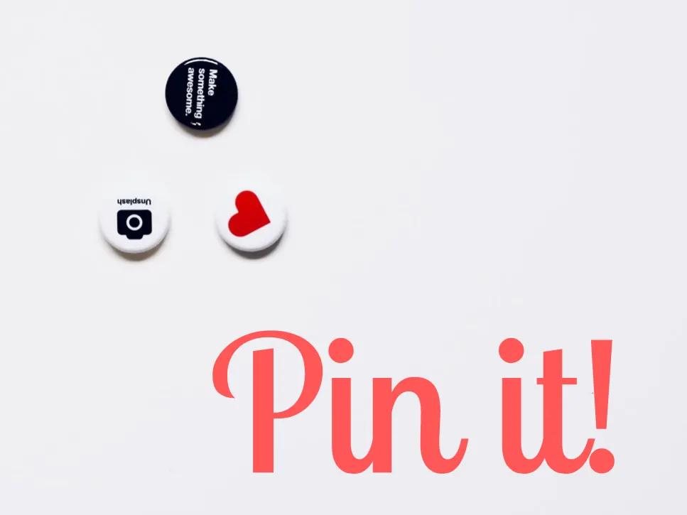 Drei Anstecker über dem handschriftlichen Schriftzug „Pin it!“ in Rot